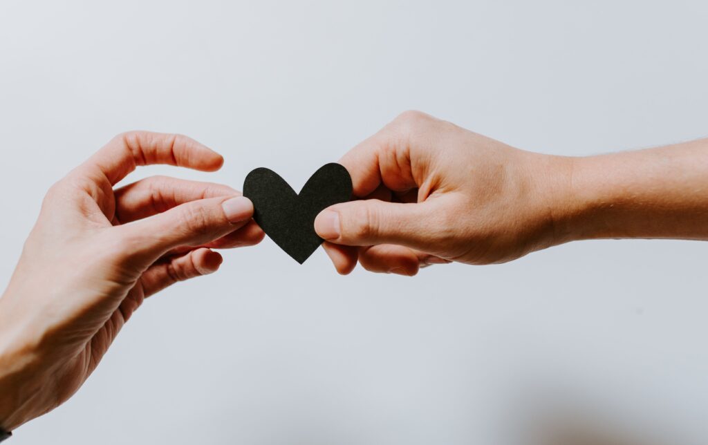Two person holding a black color paper made heart while question in mind How to Recover from a Toxic Relationship
